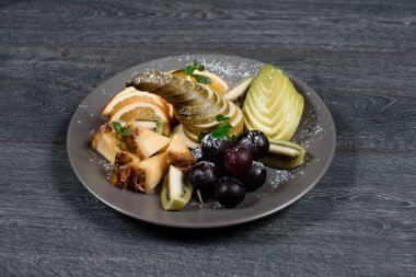 Gri masadaki taze meyve tatlısı. Geleneksel yemek menüsü bir restoranda servis edilir