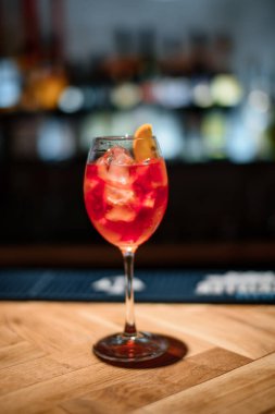 Koyu bardaki kırmızı alkol kokteyli.