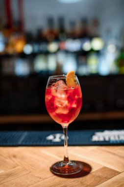 Koyu bardaki kırmızı alkol kokteyli.