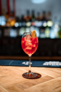 Koyu bardaki kırmızı alkol kokteyli.