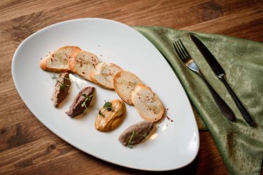 sarımsaklı ekmek ve ahşap masadaki beyaz tabakta.