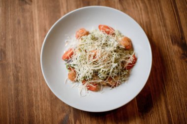 Beyaz tabak ahşap masada taze sezar karides salatası. en üstteki görünüm