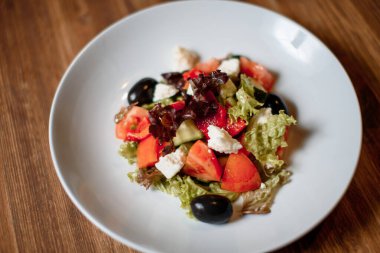 taze organik salata ve ahşap masada mavi tabakta kızarmış ekmek. Geleneksel yemek menüsü bir restoranda servis edilir