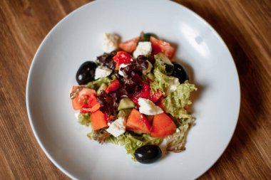 taze organik salata ve ahşap masada mavi tabakta kızarmış ekmek. Geleneksel yemek menüsü bir restoranda servis edilir