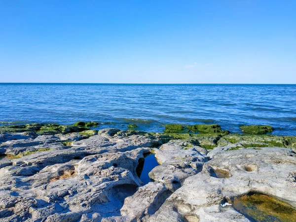Пейзаж с чистым голубым небом, океаном и камнем перед . Стоковая Картинка