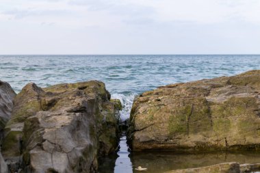 Büyük kayaların arasındaki doğal boğaz, açık denizde dalgalarla dolu bir günde. 