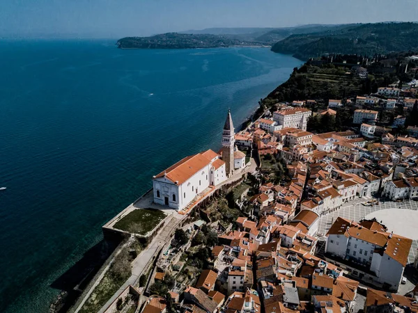 Tartini meydanlı Piran kasabası, kırmızı çatılı antik binalar, Venedik Rönesans mimarisi tarzındaki St. George Kilisesi ve güneybatı Slovenya 'daki Adriyatik denizi