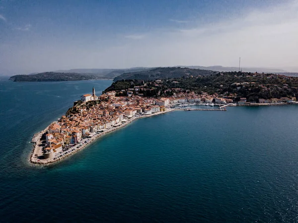 Eski deniz feneri, kırmızı çatıları olan antik binalar, güneybatı Slovenya 'da tekneleri ve Adriyatik denizi olan Piran limanı üzerindeki hava manzarası