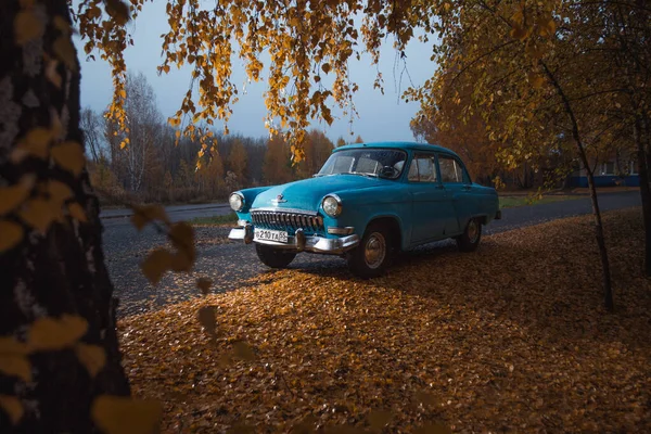Eski Rus arabası Volga GAZ 21 Yağmurlu sonbahar parkında ara sokakta