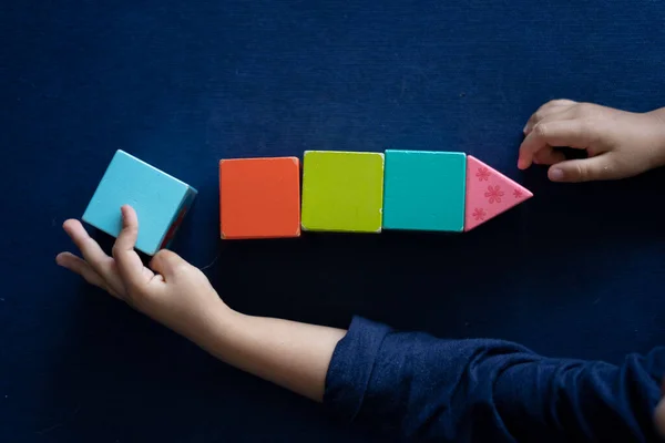 Çocuk Mavi Arkaplanda Renk Blokları Düzenliyor — Stok fotoğraf