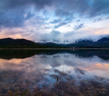 Göl üzerinde mavi gökyüzü ile pamuk bulutlar