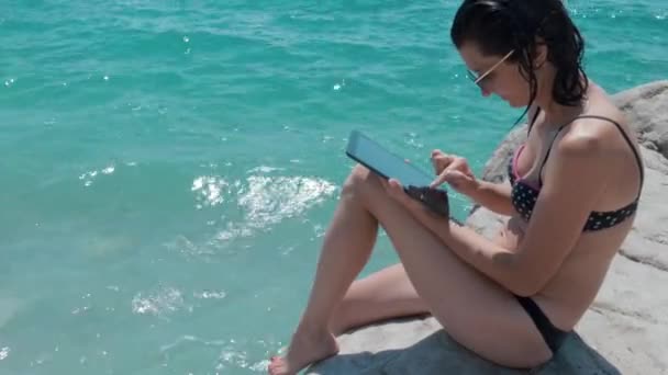 Mooie vrouw In Bikini op het strand met behulp van Tablet Pc — Stockvideo