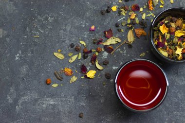 Bitki çayı gri masaya serpilmiş, iki kase Asya dikişi ile.