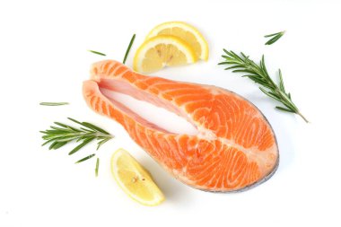 Beyaz arka planda limon ve biberiyeli somon bifteği.