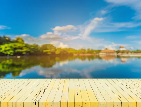 Tavolo in legno con immagine sfocata del lago . — Foto Stock