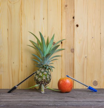 Pen-ananas-elma-kalem ahşap arka plan üzerinde.