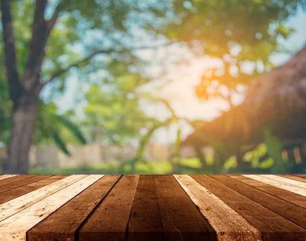 Dřevěný stůl a rozostření obrazu Bokeh Zelený strom . — Stock fotografie