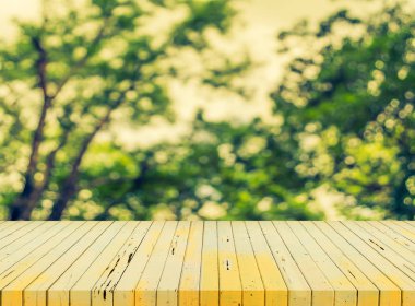 ahşap masa ve soyut yeşil ağaç görüntü bulanıklığı .