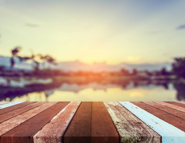 Arka planda gölün bulanık görüntüsü ve günbatımı gökyüzü 