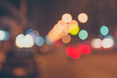 Arkaplan kullanımı için gece vakti ışıklandırmalı bulanık sokak bokeh görüntüsü .