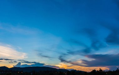 Arkaplanda dağ ve günbatımı görüntüsü.