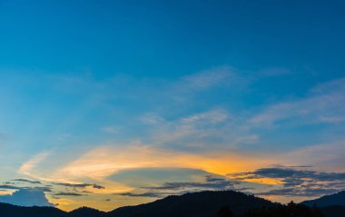 Arkaplanda dağ ve günbatımı görüntüsü.