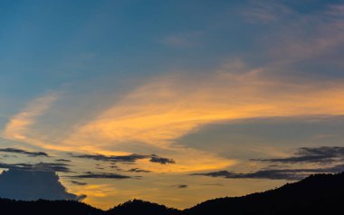 Arkaplanda dağ ve günbatımı görüntüsü.