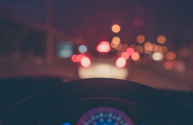 Arka plan kullanımı için gece vakti araba kullanan insanların klasik ton bulanık görüntüsü. (içeriden fotoğraf çek)