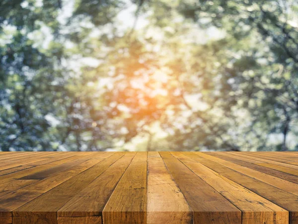 Stół z drewna i rozmycie obrazu z drzewa, zielony . — Zdjęcie stockowe