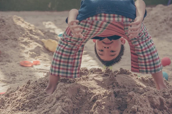 Junger asiatischer Junge spielt im Sandkasten. — Stockfoto