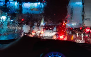 Arka plan kullanımı için gece vakti araba kullanan insanların görüntüsü. (İçeriden fotoğraf çek ön arabanın ön camına odaklan)