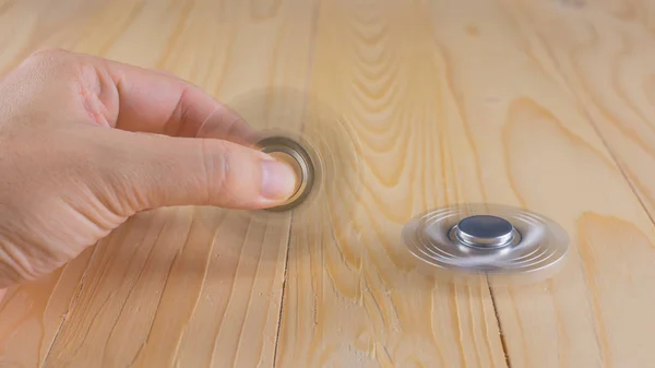 Hand with spinner on table. — Stock Photo, Image