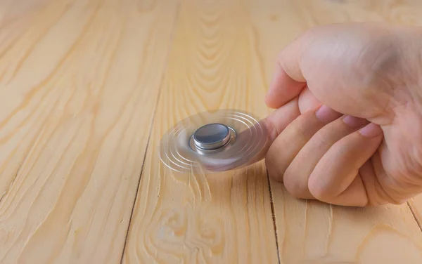 Hand with spinner on table. — Stock Photo, Image