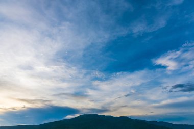   Arka planda mavi gökyüzü ve dağ.