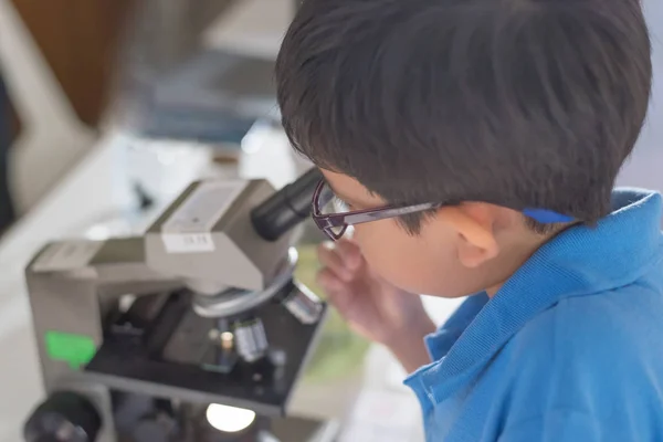 アジアの若い男の子使用顕微鏡 — ストック写真