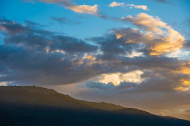   Arka planda mavi gökyüzü ve dağ.