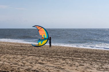 Atlantik sahilindeki uçurtma için hazırlanan kadın.
