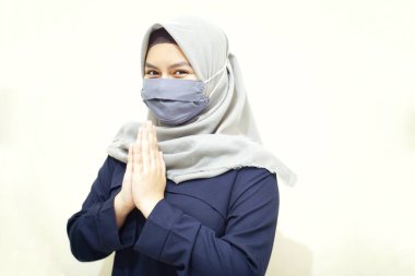Müslüman kadınlar yüz maskesi kullanarak selam veriyor. Koronavirüslü Müslüman kadınlar yüz maskesi takarak korunuyor..