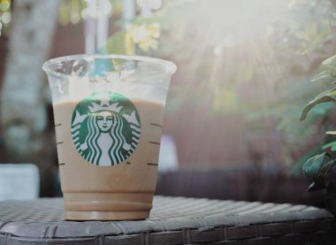 Starbucks Cafe Latte 'si, yeşil bitkilerle dolu, boşluğu kopyala.