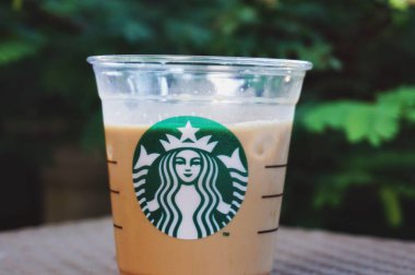 Starbucks Cafe Latte 'si, yeşil bitkilerle dolu, boşluğu kopyala.