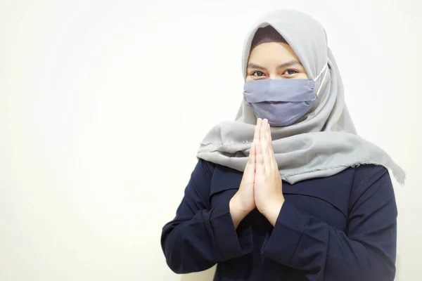 Muslim hijab women using face mask in greeting gesture. Muslim women in coronavirus prevention by using face mask.