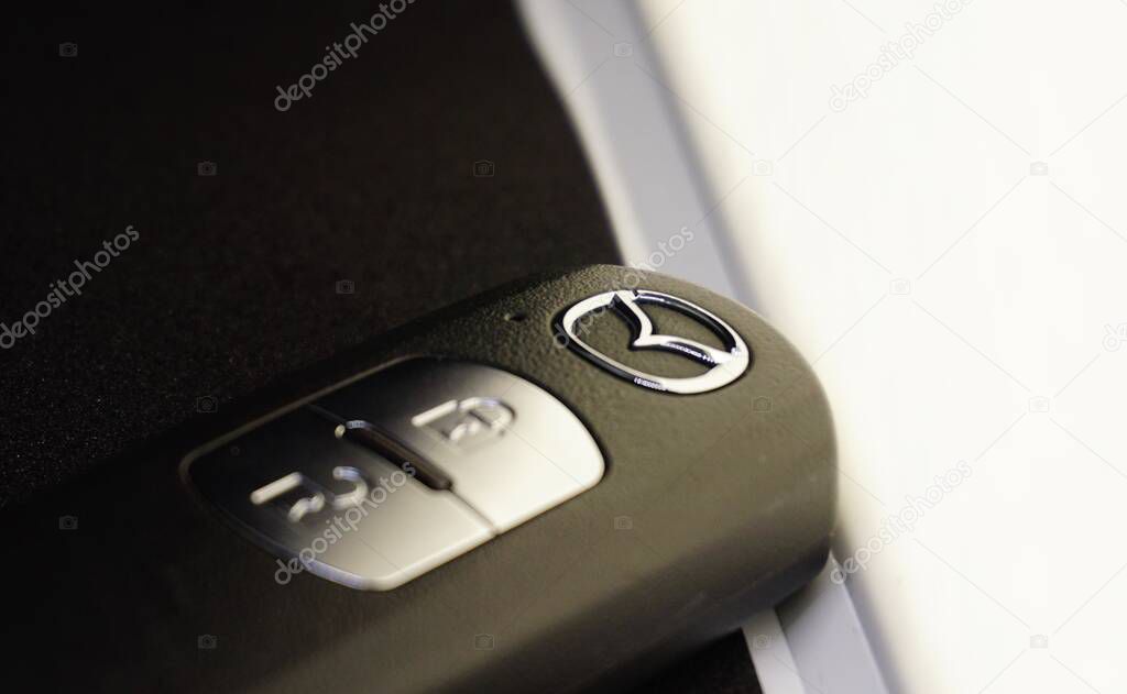 Mazda logo on a wireless car key, copy space.