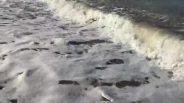 Bir yaz öğleden sonra dalgalar kayalara çarpıyor.