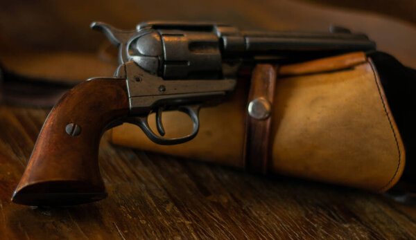 Револьвер, лежащий на кобуре справа
