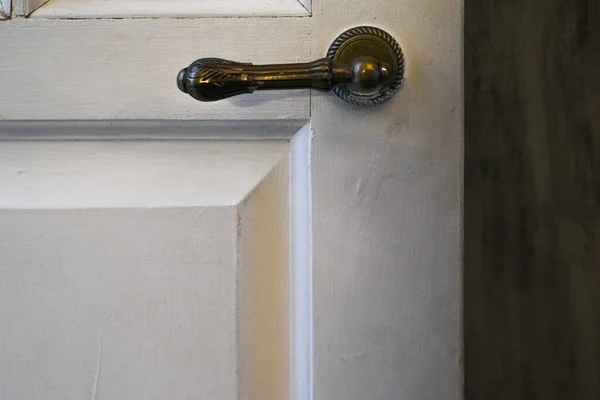 golden door knob close-up on a white door
