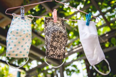 Üç çeşit kumaş maske, bir askıyla yıkanmış ve kurutulmuş..