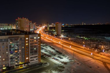 Trafik, şehrin ana caddesinde hızla ilerleyen bulanık hareketle yakalandı. Binaları aydınlattı ve bir yürüyüş yolu açtı..