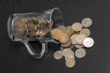 Siyah zemin üzerine cam bir kavanozdan dökülen önemsiz Rus sikkeleri, düşük çözünürlüklü madeni paralar, tasarruf.