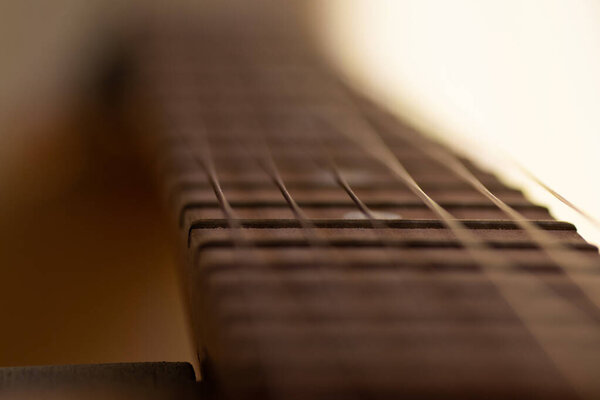 Close up detail of steel guitar strings and frets for making music. Гитаристская шея в селективном фокусе
.