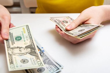 Kadın elleri dolarlarla dolu bir tomarı sayar, bir taraftan diğer tarafa kayar, finansal bağımsızlık kavramı..